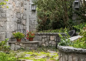 Stone garden steps leading to a charming stone cottage entrance in a lush landscaped yard in New Hope, PA.
