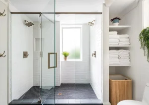 Elegant bathroom vanity with white cabinetry, dual sinks, large mirrors, and brass fixtures.