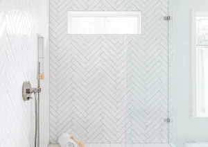 Spacious walk-in shower with frameless glass, white subway tile walls, and marble tile flooring.