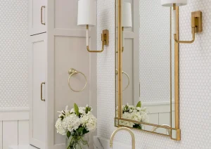 Wall-mounted sconce lighting and brass-framed mirror over quartz vanity in New Hope, PA upscale bathroom design
