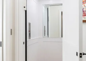 Transitional hallway with white paneled door and light oak flooring in Newtown, PA remodel.