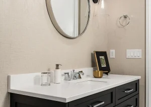 Stylish bathroom vanity with oval mirror, black fixtures, and wall-mounted sconces in Newtown, PA.