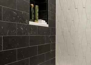 Black tile shower with built-in niche and matte gold fixtures in a luxury Newtown, PA bathroom remodel.