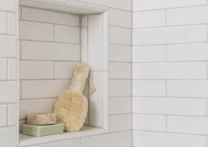Shower niche with warm-toned accessories and white subway tile in upscale New Hope, PA bathroom