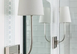 Close-up of modern wall sconce lighting above white subway tile in a New Hope, PA bathroom remodel.